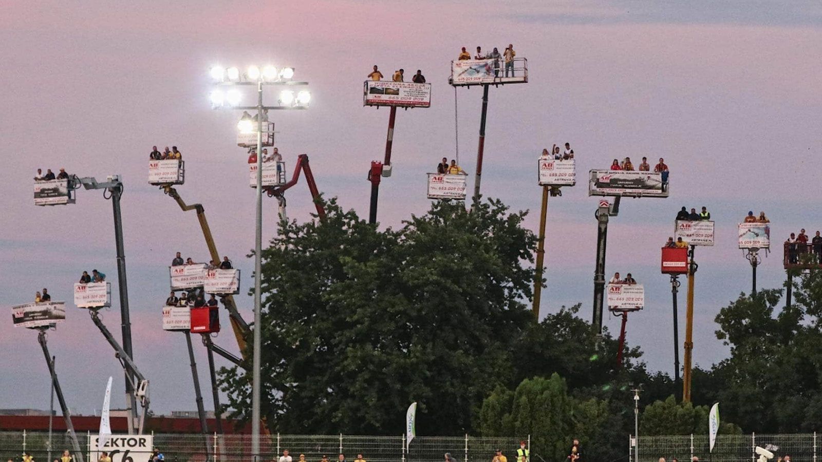 
                <strong>Speedway-Fans werden erfinderisch</strong><br>
                Wer in der Corona-Krise Profisport live vor Ort miterleben möchte, braucht kreative Ideen. Wie Fans des polnischen Speedway-Teams Motor Lublin. Mehrere Dutzend schwindelfreie Anhänger der Racer mieteten sich insgesamt 20 Kräne samt Hebebühnen an, um sich während eines der auf Ovalkursen ausgetragenen Wettbewerbe in die Luft bugsieren zu lassen und aus der Höhe auf ihre Idole herabschauen zu können. Das muss echte (Fan-)Liebe sein!
              