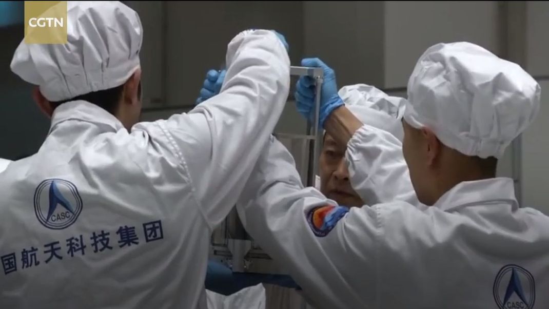 Der große Moment: Chinesische Wissenschaftler ziehen den Probenbehälter aus der Rückkehrkapsel  von Chang'e 5