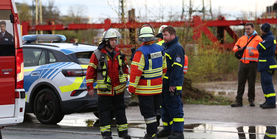 04.04.2024, Bayern, Neumarkt in der Oberpfalz: Polizei und Feuerwehr stehen an einem Gewerbegebiet. Ein Mensch wurde in diesem Bereich von einem Zug erfasst.