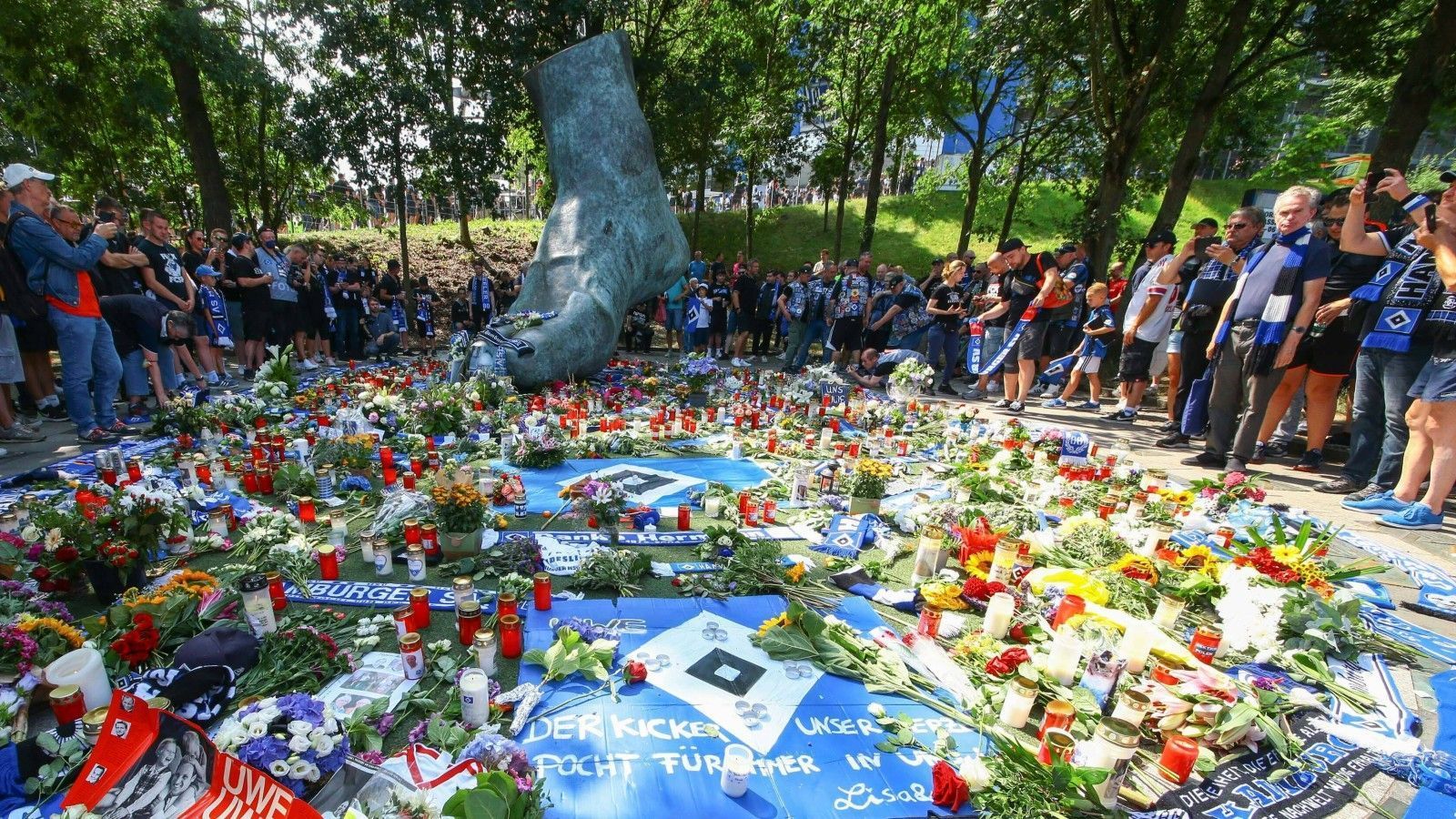 
                <strong>Gedenken vor dem Stadion</strong><br>
                Bereits vor der Partie gedenken die Fans der verstorbenen Fußball-Legende und legen an seinem bronzenen Fuß vor dem Stadion Blumen, Kerzen und Fanutensilien nieder.
              