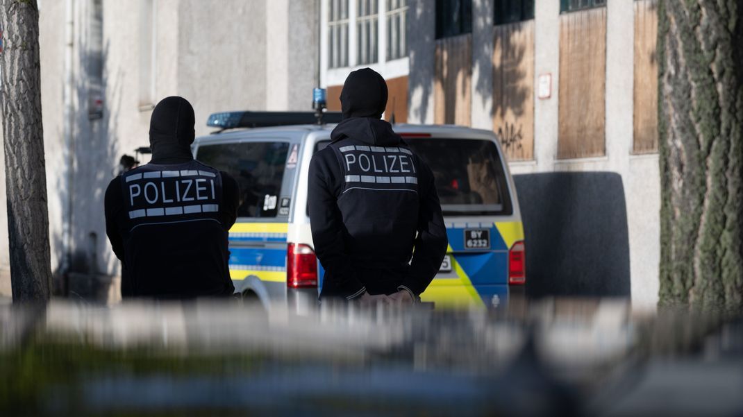 Einsatzkräfte der Polizei stehen im Rahmen eines Einsatzes gegen eine georgische Hehlerbande vor einem Gebäude in der Innenstadt.