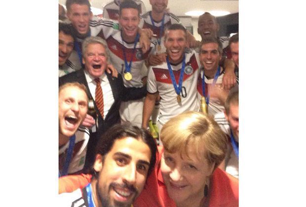 
                <strong>Sami Khedira</strong><br>
                Sami Khedira postet ein Bild von sich und Angela Merkel, im Hintergrund das restliche Team.
              