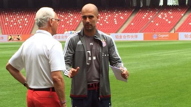 
                <strong>Der FC Bayern auf China-Tour</strong><br>
                Angekommen im Nationalstadion von Peking macht sich Pep Guardiola (r.) ein Bild von den Gegebenheiten. Zudem tauscht sich der Spanier mit Franz Beckenbauer (l.) aus.
              