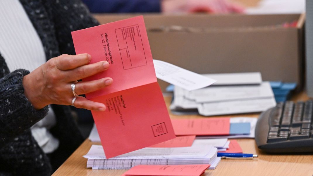 Mitarbeiter:innen bereiten Wahlunterlagen für die Briefwahl in Berlin vor. Fünf Wochen vor der Wahl gibt es die erste Panne.