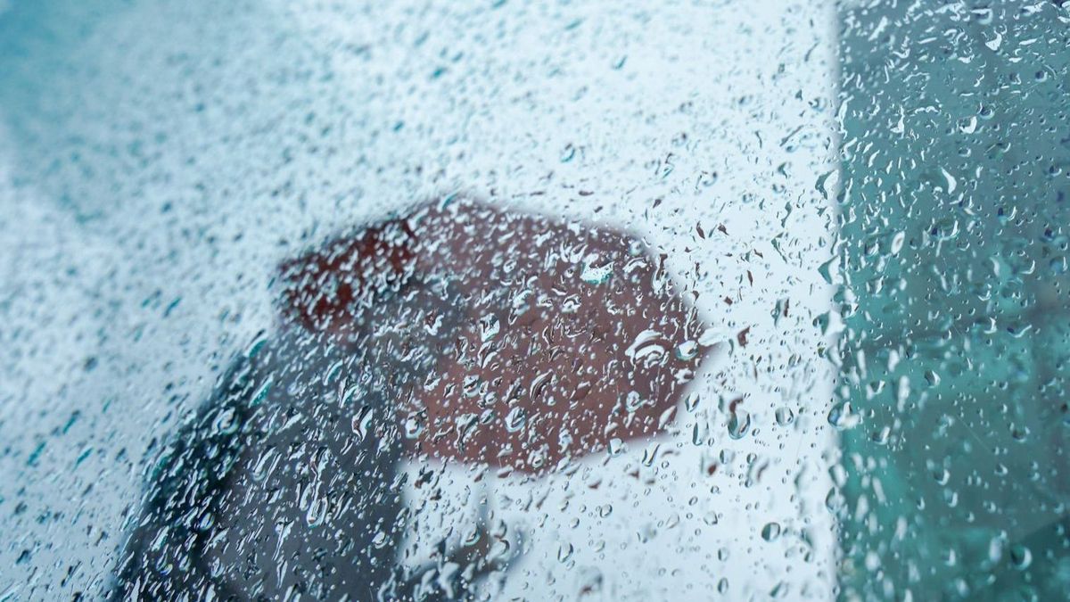 Person mit Regenschirm im Regenwetter