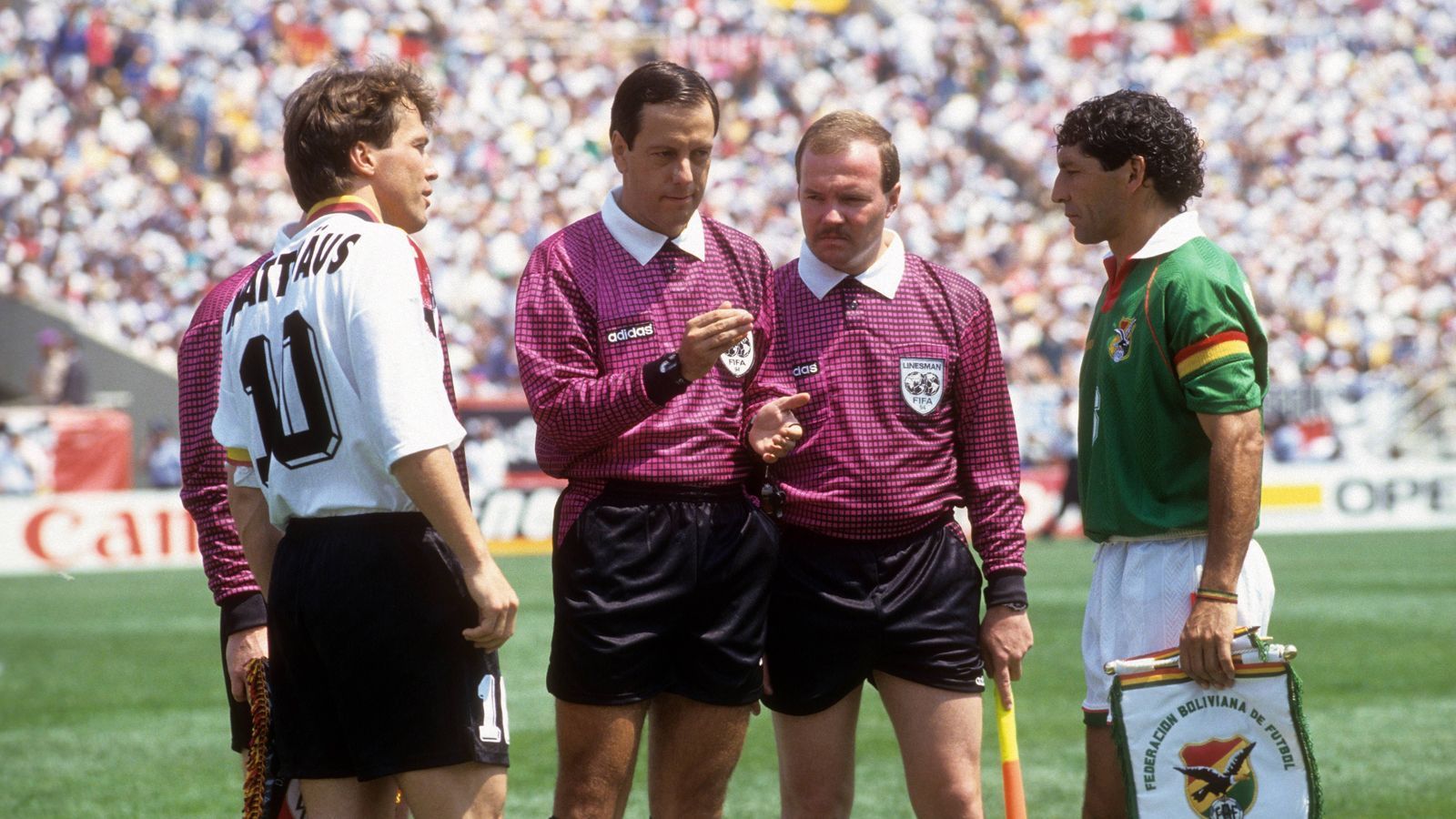 
                <strong>1994: Deutschland – Bolivien 1:0</strong><br>
                In der Hitze von Chicago quält sich der Weltmeister zu einem mühsamen 1:0-Erfolg gegen den Underdog Bolivien. In der deutschen Startelf stehen noch neun Weltmeister. Jürgen Klinsmann gelingt nach einer Stunde das goldene Tor. Für Kapitän Lothar Matthäus (im Bild li. mit Boliviens Carlos Borja) ist es die vierte WM.
              