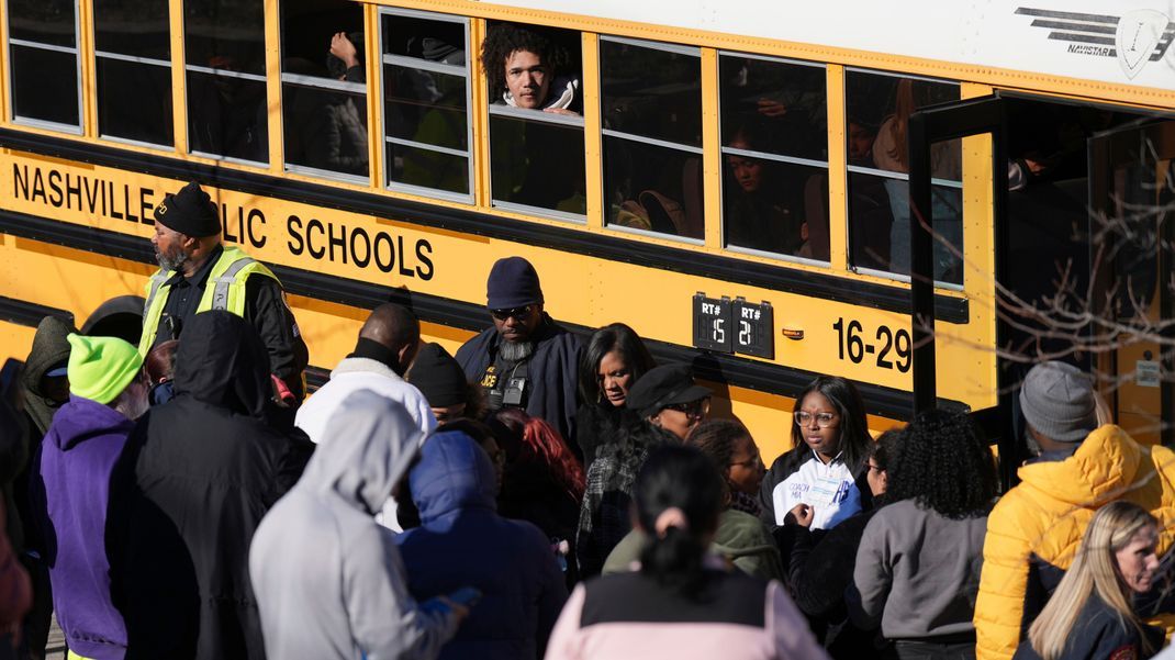 Schüler:innen warten darauf, an einem Vereinigungsort aus einem Schulbus zu steigen, nachdem an der Antioch Highschool Schüsse gefallen waren.