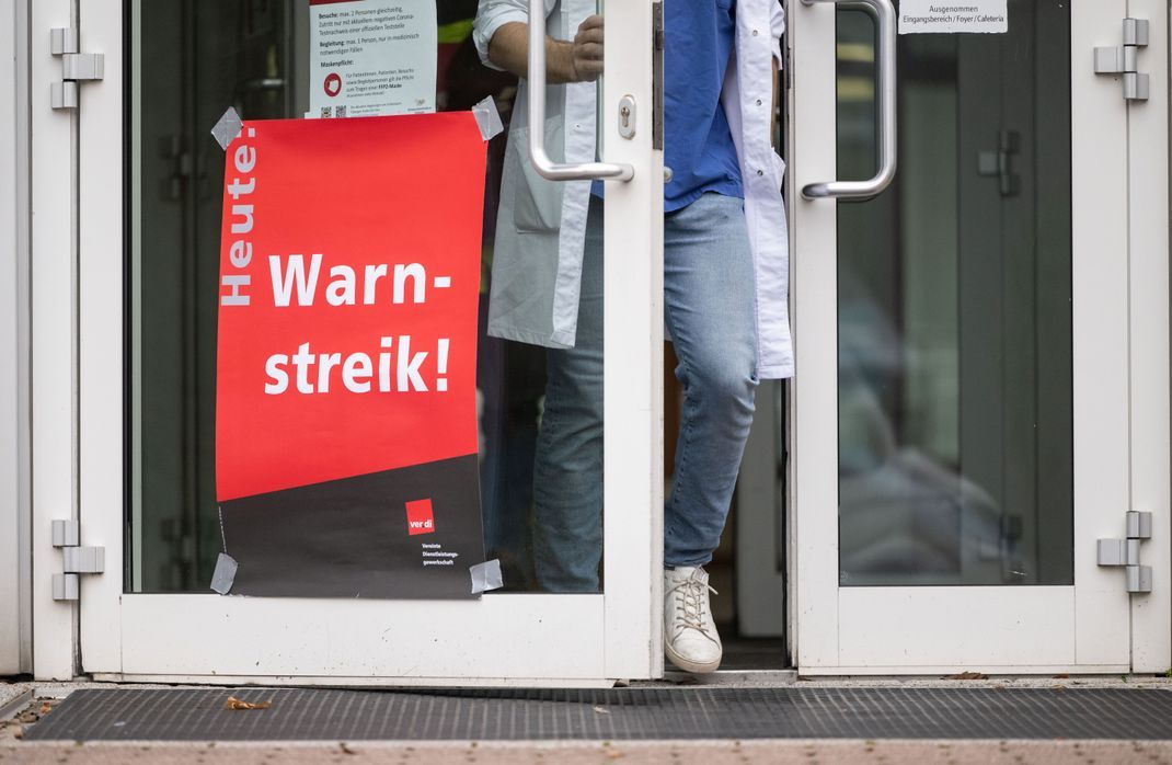 Ein Plakat mit der Aufschrift "Heute Warnstreik" hängt am Eingang eines Gebäudes des Universitätsklinikums Tübingen