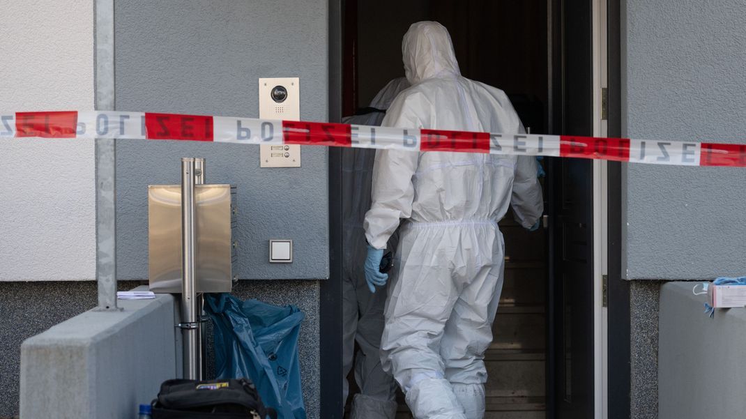 Beamte der Spurensicherung der Polizei begutachten in Darmstadt-Arheilgen den Tatort.