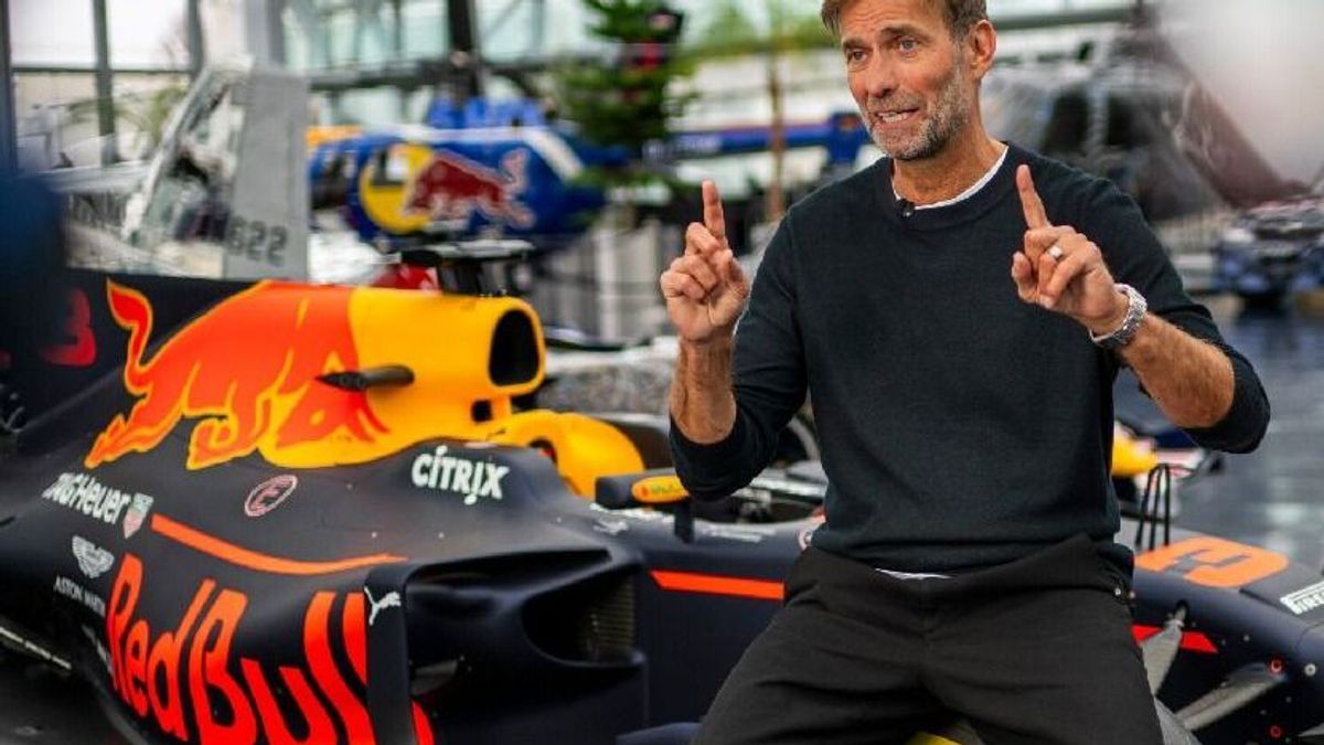 Fußball-Trainer Jürgen Klopp mit einem Formel-1-Auto von Max Verstappen bei Red Bull