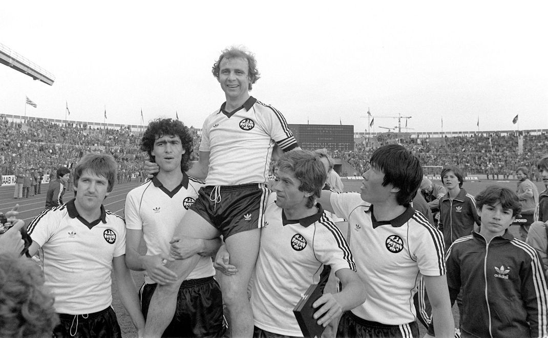 Der Frankfurter Eintracht-Stürmer und Kapitän Bernd Hölzenbein (oben) wird bei Spielende von seinen Teamgefährten Bernd Nickel (von links nach rechts), Bruno Pezzey sowie Werner Lorant und Bum-Kun Cha auf Schultern getragen. 1981 gewann Eintracht Frankfurt das DFB-Pokalendspiel.