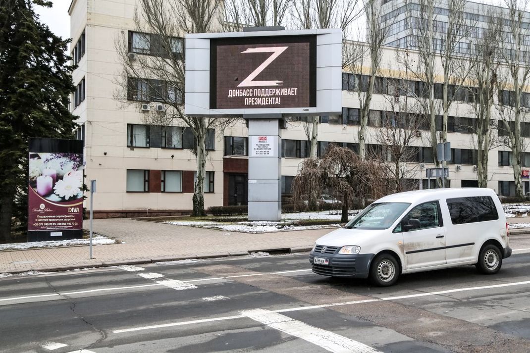 Auf einer Plakatwand im Donbass, wo auch die selbsternannten Volksrepubliken Donezk und Luhansk liegen, soll laut dieses von der russischen Staatsagentur TASS veröffentlichten Bildes das Z-Symbol mit einem Schriftzug zu sehen sein, der ins Deutsche übersetzt "Donbass unterstützt den Präsidenten" bedeutet.