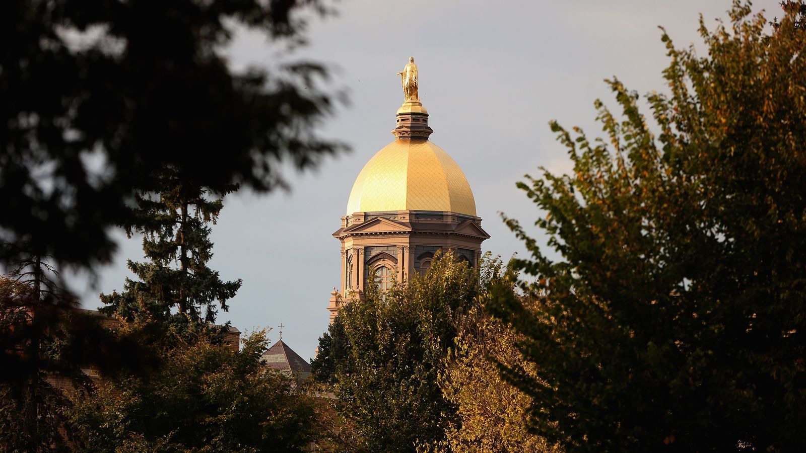 
                <strong>Universität</strong><br>
                Die University of Notre Dame wurde 1842 vom französischen Priester Edward Sorin im gleichnamigen Ort im Bundesstaat Indiana gegründet. Die katholische Privatuniversität zählt zu den akademischen Elite-Universitäten und ist eine der zehn reichsten Universitäten in den USA. Die Wahrzeichen sind neben dem Football-Stadion der "Golden Dome" (Bild), eine vergoldete Kuppel mit einer Statue von Maria, und die Herz-Jesu-Basilika.
              