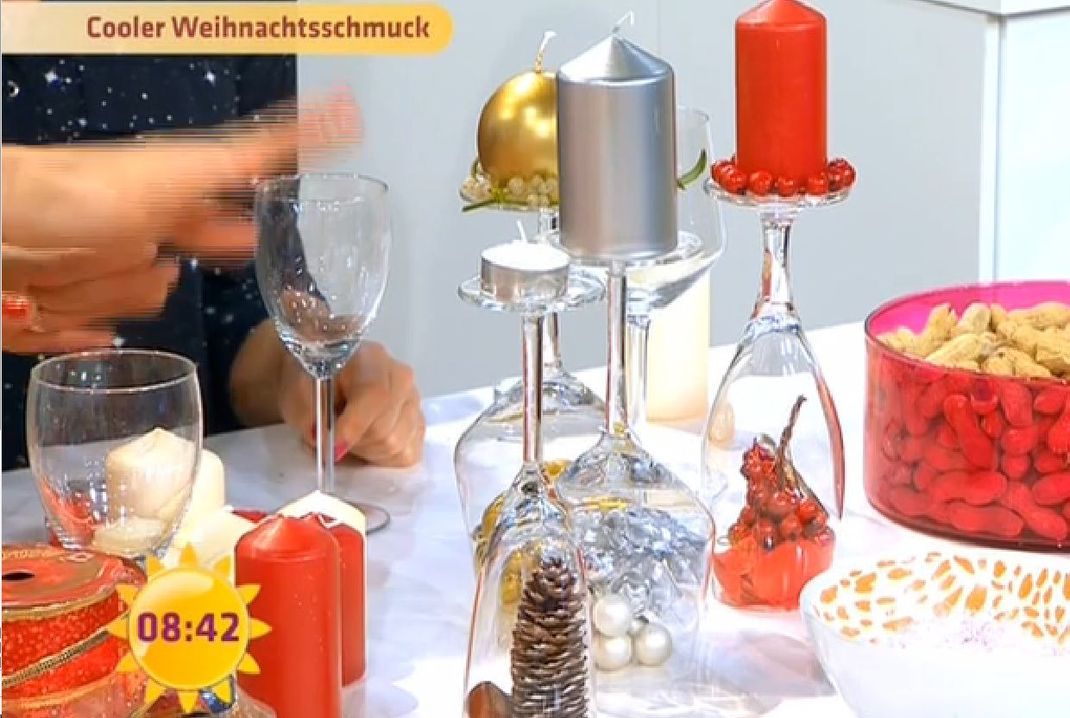 Möchten Sie Ihren Tisch weihnachtlich dekorieren, sollten Sie die Kerzen nicht vergessen. Auf umgedrehten Weingläsern kommen sie besonders gut zur Geltung.