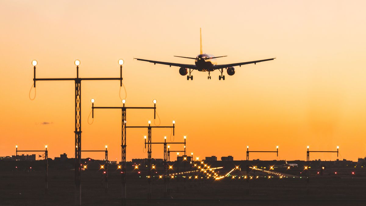 Airplane landing at sunset, silhouette