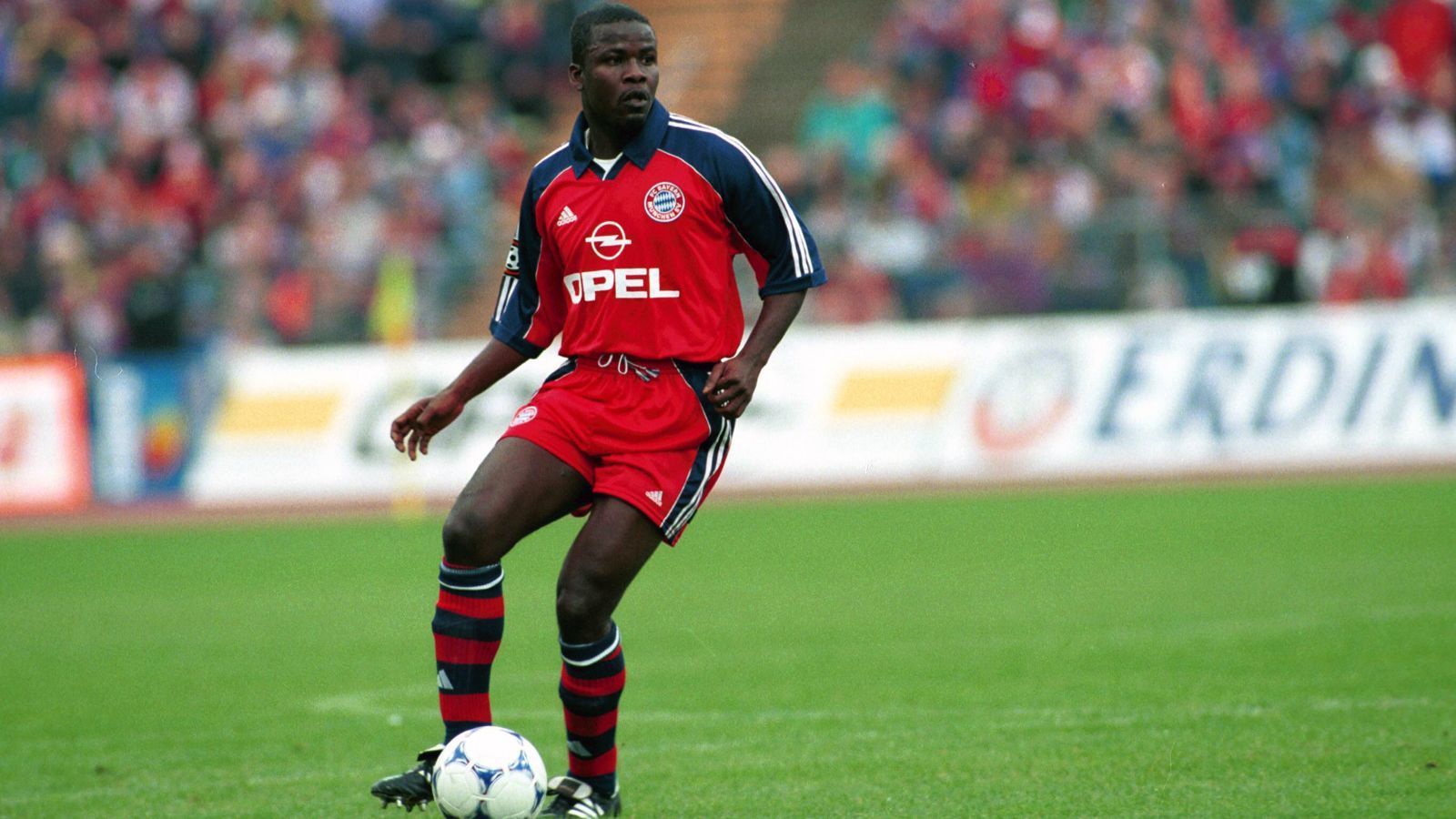 
                <strong>Samuel Kuffour</strong><br>
                Mit gerade einmal 16 Jahren schnappte sich Bayern München 1993 das damalige Defensivtalent Samuel Kuffour vom FC Turin - eine lohnende Investition in die Zukunft! Der Teenager aus Ghana biss sich an der Isar durch und blieb über ein Jahrzehnt Bestandteil der Münchner Mannschaft (277 Einsätze), feierte mit dem FCB unter anderem einen Champions-League-Titel, sechs Meistertitel und vier Pokalsiege. Legendär ist er bis heute für seine teilweise leichtsinnige Spielweise und den ein oder anderen dicken Bock. So knockte der Innenverteidiger einmal (unabsichtlich) seinen Keeper Oliver Kahn aus. Andererseits sorgte Kuffour 2001 mit seinem Siegestor für den Bayern-Triumph im Kampf um den Weltpokal. Nach Kuffours FCB-Abgang im Jahr 2005 spielte der Afrikaner unter anderem noch für die AS Rom und Ajax Amsterdam. 
              