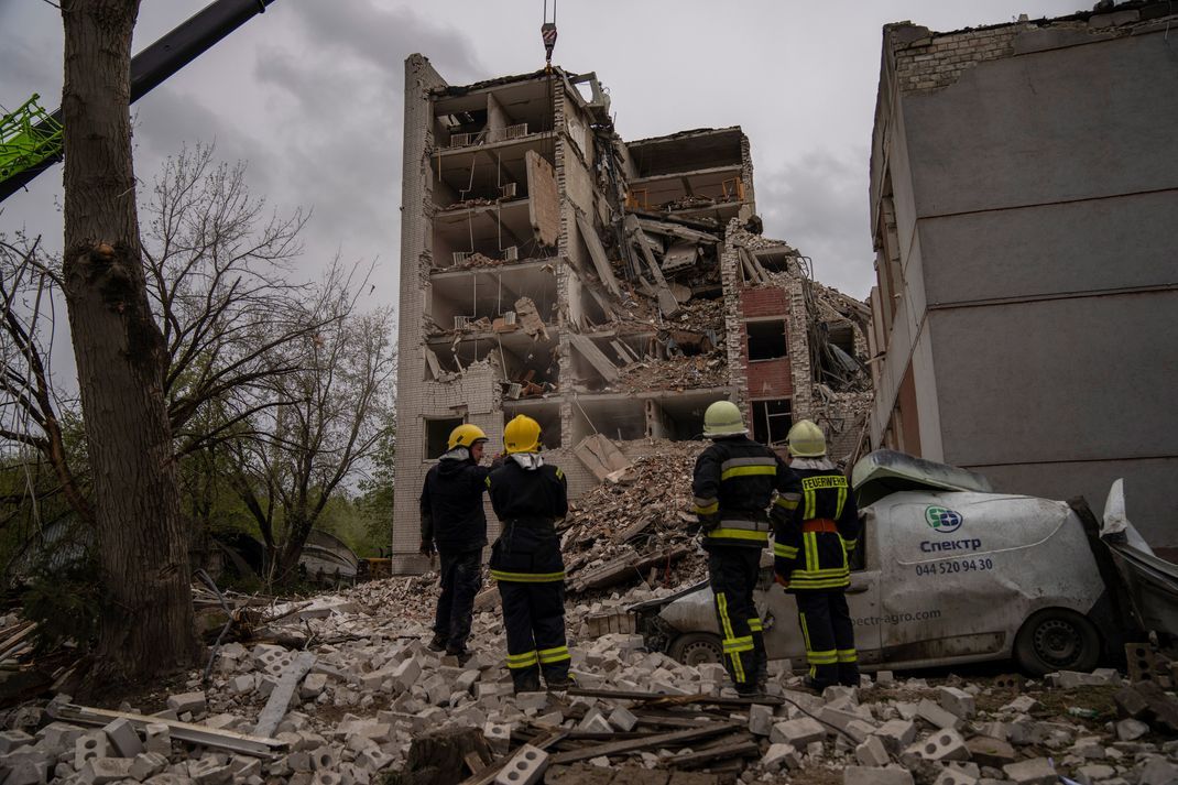 Feuerwehrleute betrachten ein zerstörtes Gebäude in Tschernihiw. (Symbolbild)