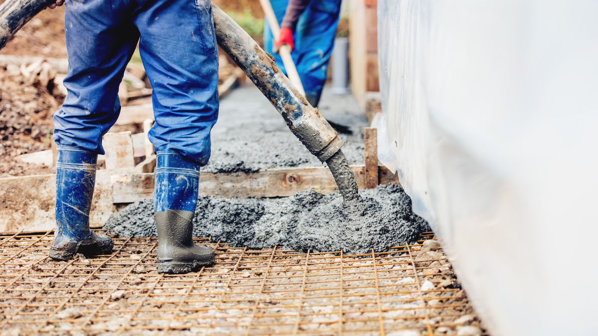 Constuction details - worker laying cement or concrete with automatic pump