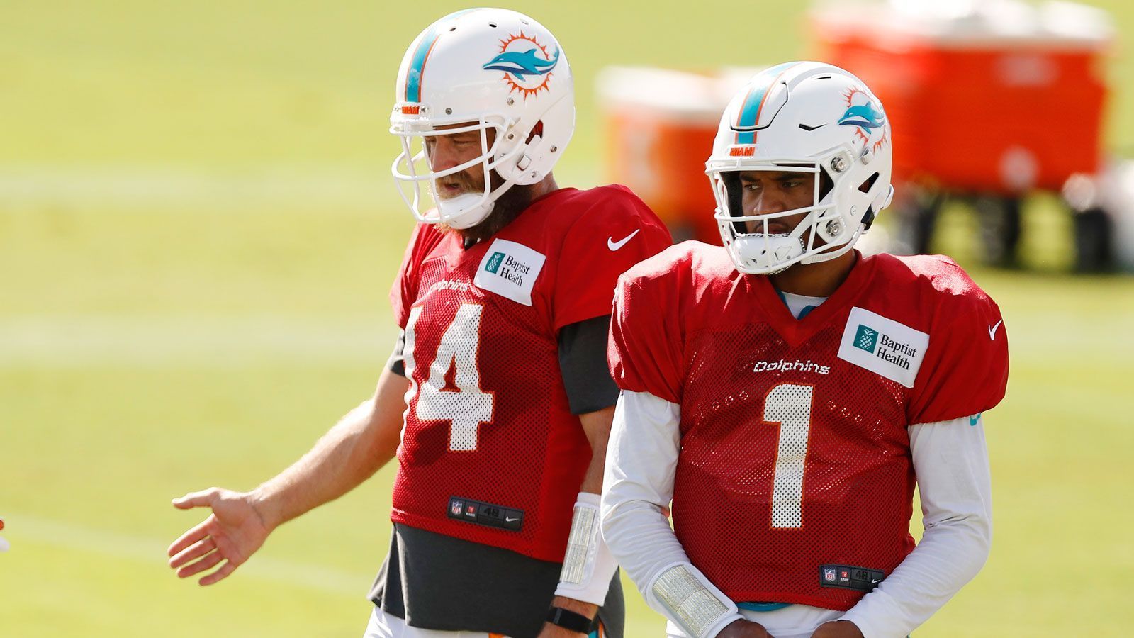 
                <strong>Mit dem 5. Pick nach Miami</strong><br>
                Trotz der schweren Verletzung im November 2019 wählen die Miami Dolphins den Spielmacher an der fünften Stelle des NFL-Drafts aus. Im Juli 2020 besteht er seinen Medizincheck in Miami und nimmt daraufhin am Training Camp des Klubs teil. Head Coach Brian Flores spricht sich allerdings frühzeitig für Routinier Ryan Fitzpatrick (li.) als Starter aus, sodass Tagovailoa, wie auch schon im College, erstmal die Rolle des Backups einnimmt. Fitzpatrick führt die Dolphins überraschend gut durch den ersten Teil der Saison und gewinnt drei von sechs Spielen.
              