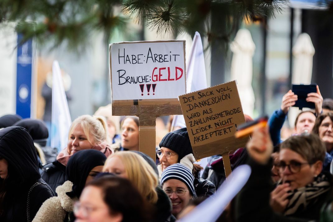 Schilder werden bei einer Kundgebung von Medizinischen Fachangestellten (MFA) zum Warnstreik des Verbands medizinischer Fachberufe (Vmf) in Berlin hochgehalten.