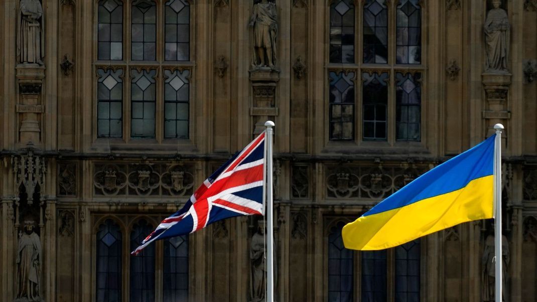 24. August 2022, Großbritannien, London: Eine Union-Jack-Flagge und eine ukrainische Flagge wehen vor den Houses of Parliament am Unabhängigkeitstag der Ukraine.