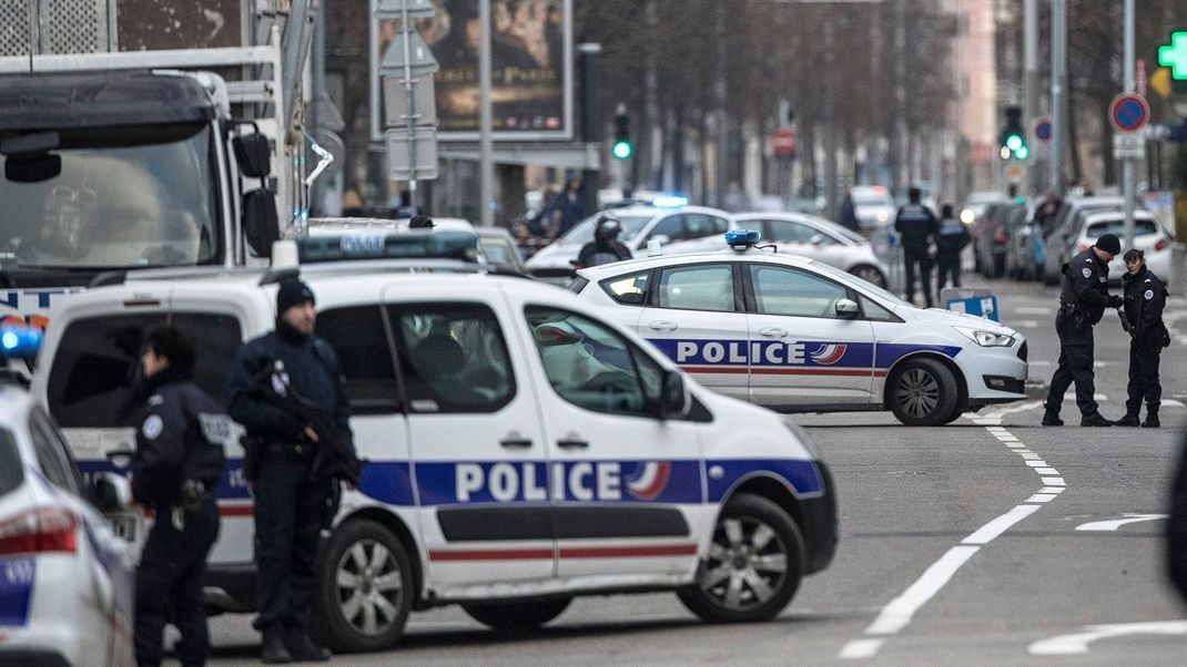 Französische Polizisten blockieren während eines Einsatzes in einem Stadtteil von Straßburg eine Straße.
