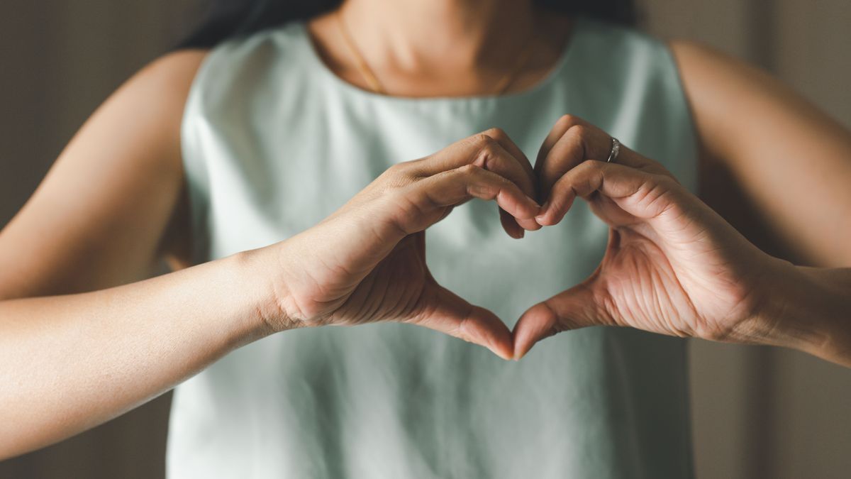 Close up of woman making heart shape for Valentines day, Mothers day and Breast Cancer Awareness month for Healthcare of International Women day