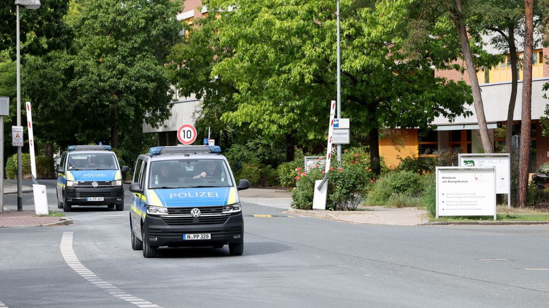 Zwei Fahrzeuge der Polizei verlassen das Gelände von dem Klinikum am Europakanal. 