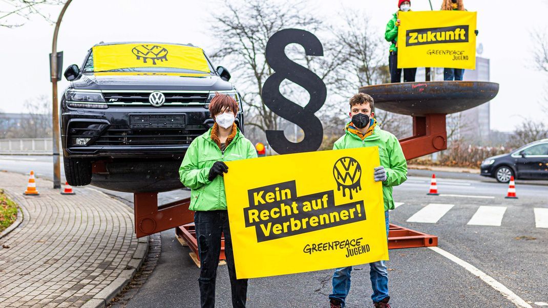 Aktivist:innen der Umweltschutzorganisation Greenpeace demonstrieren mit einer überdimensionalen Waage vor der Volkswagen-Aufsichtsratssitzung dafür, dem Schutz des Klimas mehr Gewicht zu geben.