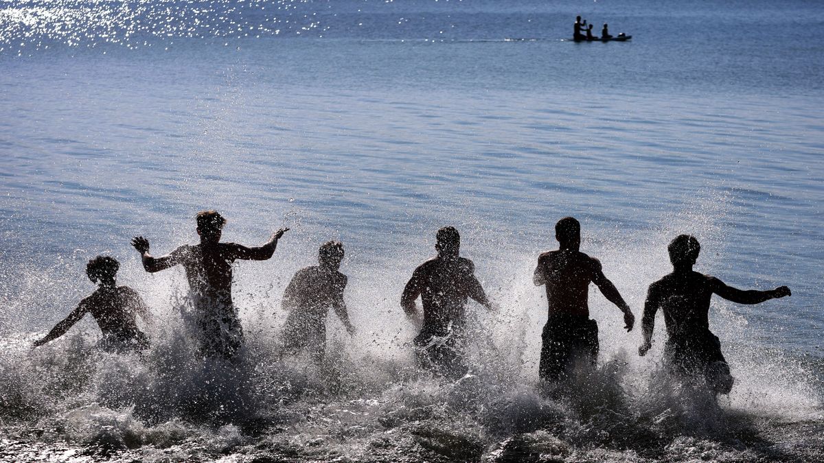 Junge Männer stürzen sich bei noch kühler Wassertemperatur in den Starnberger See.