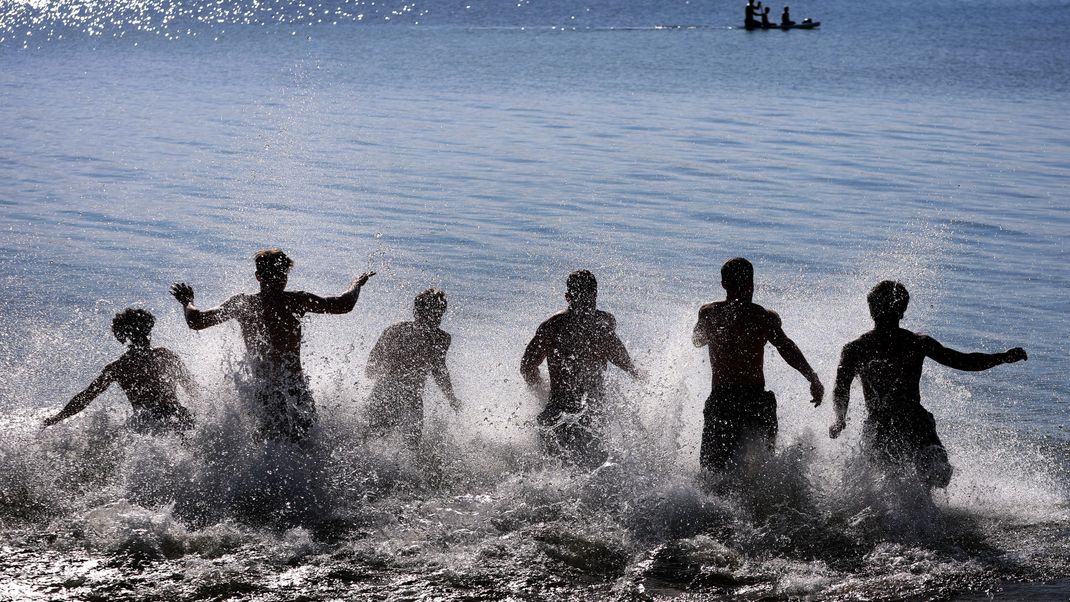 Junge Männer stürzen sich bei noch kühler Wassertemperatur in den Starnberger See.