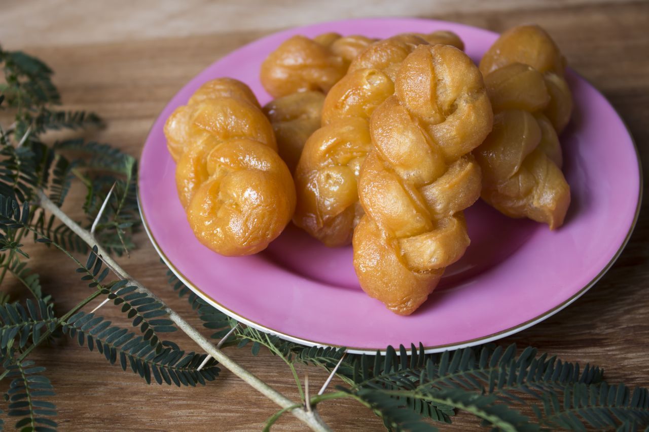 Koeksisters sind ein traditionelles Dessert aus Südafrika. Die frittierten Teigzöpfe werden durch einen speziellen Sirup gezogen.