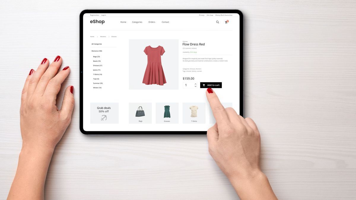 Online shopping with a tablet. Red women's dress on the e-commerce web page