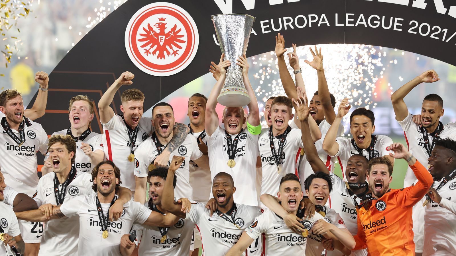 
                <strong>Da ist das Ding</strong><br>
                Frankfurt-Kapitän Sebastian Rode bekam den Pokal übergeben und durfte ihn als erster Eintracht-Spieler in den Nachthimmel von Sevilla stemmen. Der Mittelfeldspieler verletzte sich früh in der Partie und musste anschließend mit einem Turban weiterspielen.
              