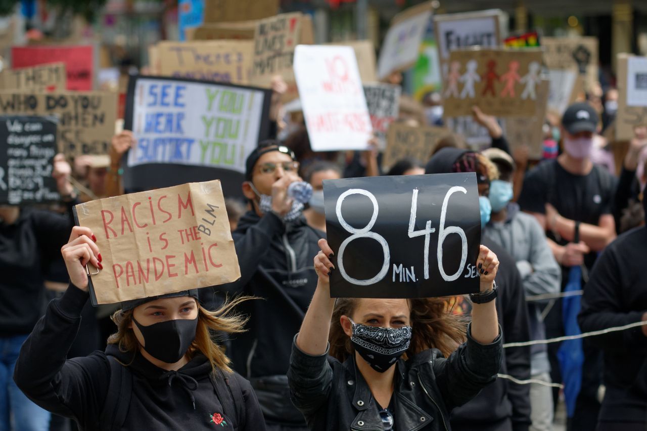 Beim Protestmarsch durch die Düsseldorfer Innenstadt liefen rund 20.000 Menschen mit. Eine Teilnehmerin der "Silent Demo"  hält ein Schild mit den Worten "8 Min. 46 Sek." hoch. So lange kniete ein weißer Polizist auf dem Nacken von George Floyd.