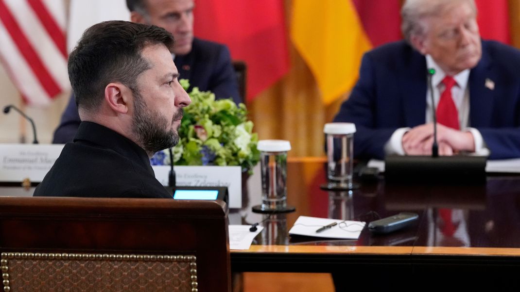 Wolodymyr Selenskyj (vorne), Präsident der Ukraine, Emmanuel Macron, Präsident von Frankreich, und US-Präsident Donald Trump (r) sitzen bei einem Treffen im Weißen Haus. 