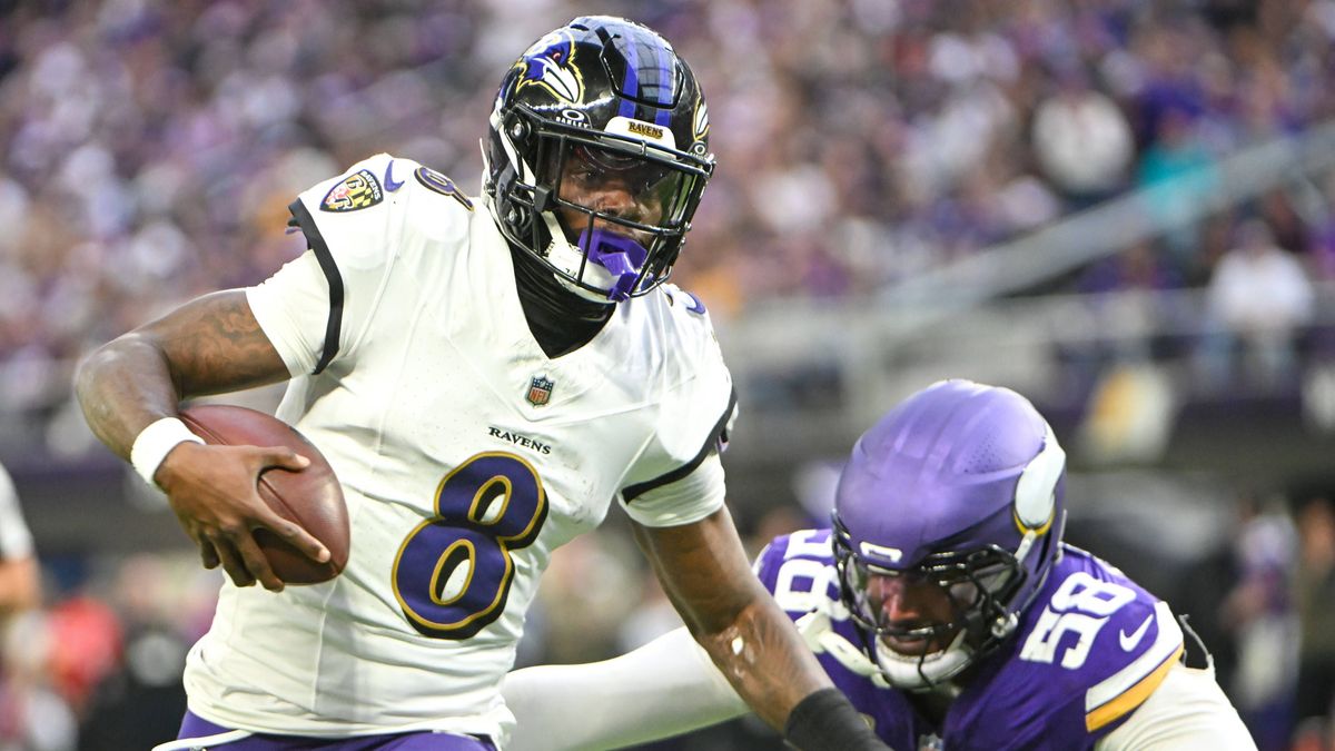 Baltimore Ravens quarterback Lamar Jackson (L) runs past Minnesota Vikings linebacker Jonathan Greenard (R) in the third quarter at U.S. Bank Stadium in Minneapolis, Minnesota on Sunday, November 9...