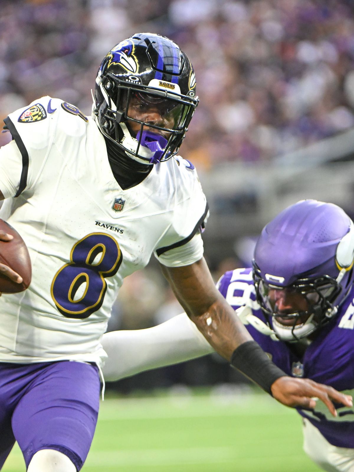 Baltimore Ravens quarterback Lamar Jackson (L) runs past Minnesota Vikings linebacker Jonathan Greenard (R) in the third quarter at U.S. Bank Stadium in Minneapolis, Minnesota on Sunday, November 9...
