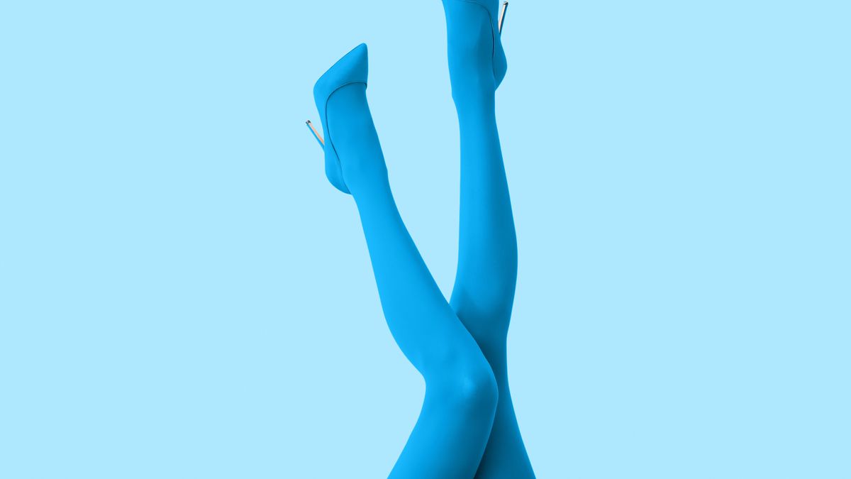 Legs of beautiful young woman in tights and high-heeled shoes on color background