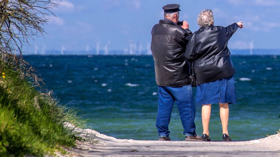 Ein Rentnerpaar steht am Timmendorfer Strand.