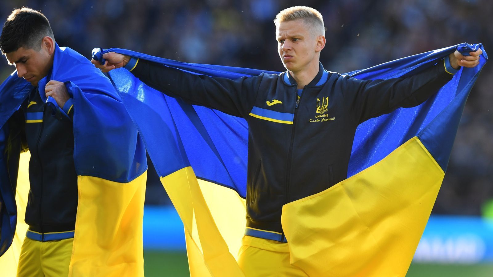 
                <strong>Zinchenko und Co. kamen mit ukrainischer Flagge aufs Feld</strong><br>
                ... der Profi von Manchester City stand in der Startelf der Gäste, die in die ukrainische Flagge gehüllt auf das Spielfeld kamen. 
              