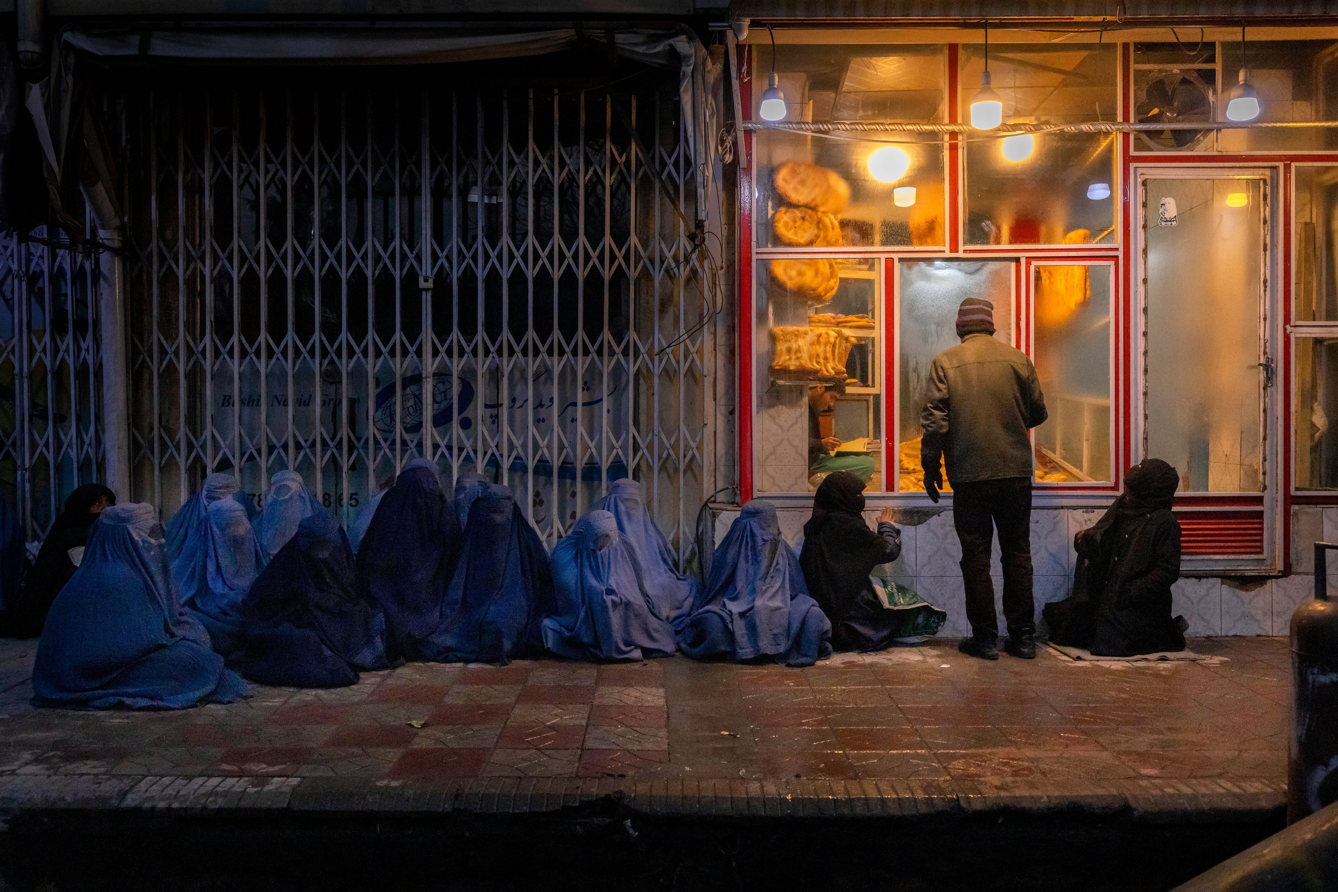 Afghanistan: Frau und Kinder betteln vor einer Bäckerei im Zentrum Kabuls um Essen.