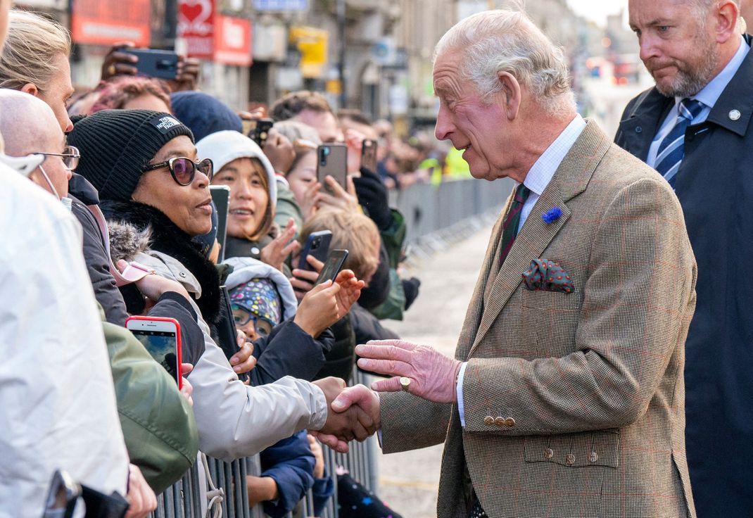 König Charles III. spricht auf der Straße mit wartenden Menschen bei einem Besuch im schottischen Aberdeen.