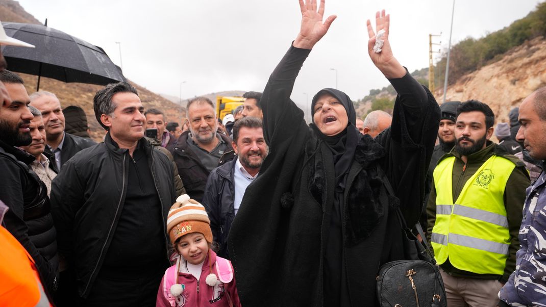 Der geschäftsführende Verkehrsminister Ali Hamieh (l.) begrüßt vertriebene Einwohner:innen, die aus Syrien zurückkehren, am Grenzübergang Masnaa im Ostlibanon, nachdem zwischen Israel und der Hisbollah eine Waffenruhe geschlossen wurde.