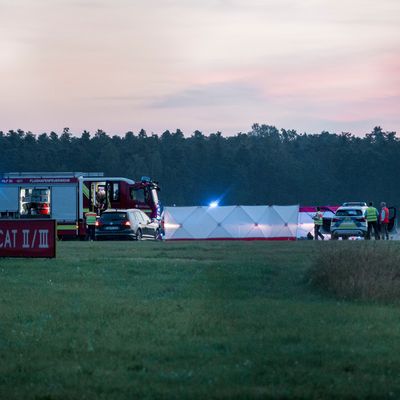 Polizisten arbeiten hinter Sichtschutzblenden an Aktivisten der Klima-Initiative Letzte Generation auf dem Nürnberger Flughafen. 