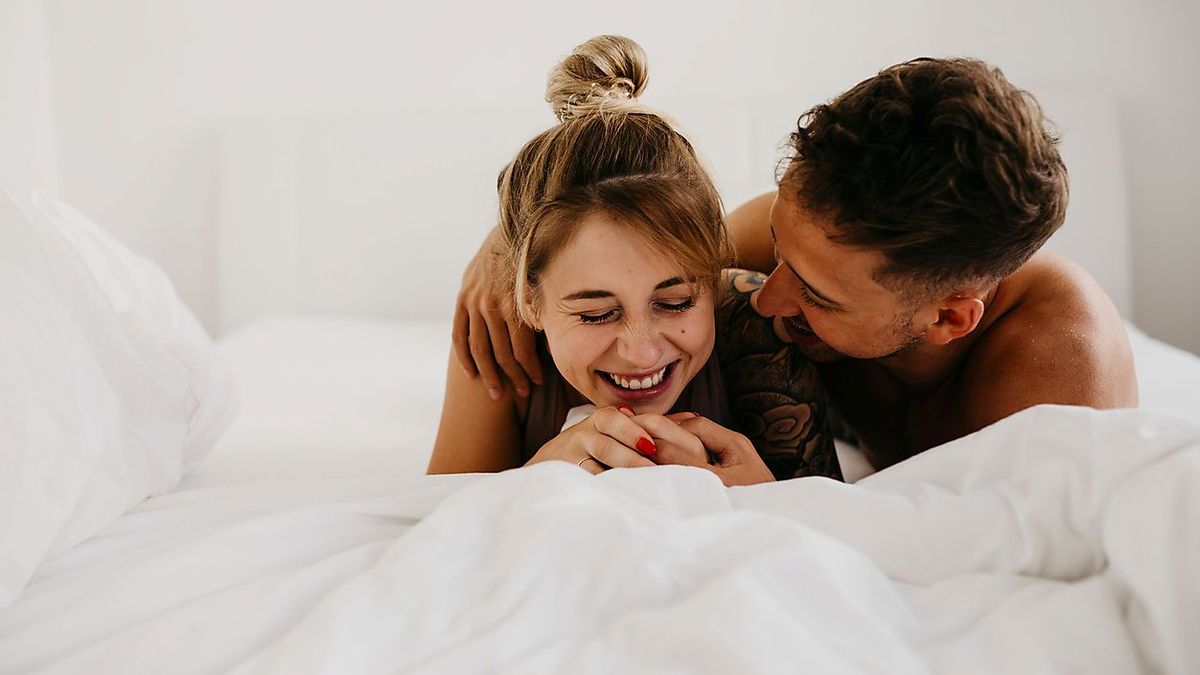 Romantic happy young couple lying in bed