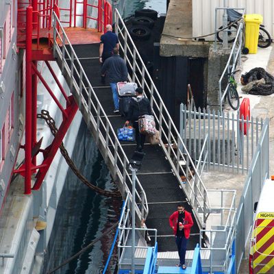 Menschen gehen im Hafen von Portland an Bord des Unterkunftsschiffs «Bibby Stockholm»