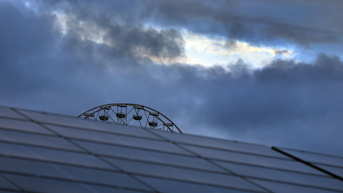 Das Riesenrad des Freizeitparks Allgäu Skyline Park, steht am frühen Morgen vor wolkenüberzogenen Himmel.