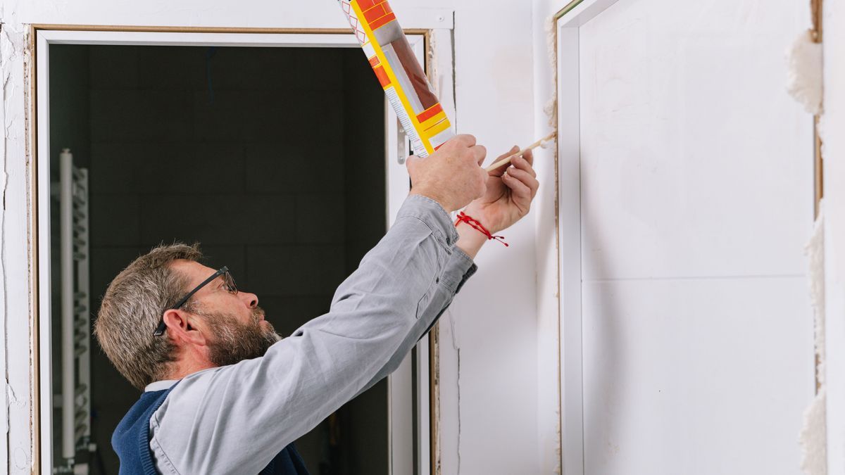 Man using expanding foam on doorway