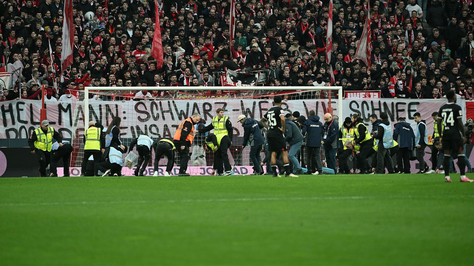 <strong>Ordnerdienst ist einmal mehr gefordert</strong><br>Um den Rasen von den aufs Feld geworfenen Süßigkeiten zu befreien, musste das Ordnerteam in Freiburg ran.